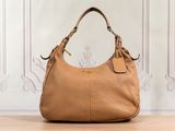 un sac à main marron posé sur une table en bois