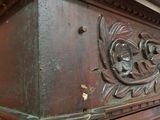 a wooden bed with a carved headboard on top of it