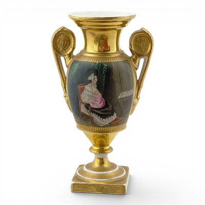 a gold vase with a picture of a woman on it