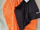 a pair of orange pants and an orange jacket on a bed