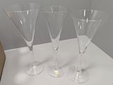 trois verres à vin vides posés sur une table blanche