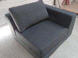 a grey chair that is sitting in a room