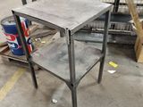 a metal table with a shelf on it in a warehouse