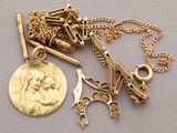 a gold necklace with a coin and a pair of scissors on it