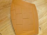 a piece of orange plastic on a wooden table