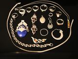 many different types of jewelry displayed on a black surface