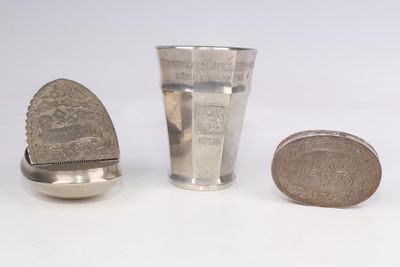 une coupe en argent et une cuillère en argent à côté d'une pièce de monnaie