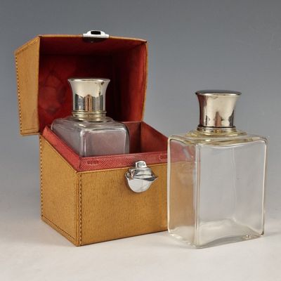 two bottles of perfume sitting in a box on a table