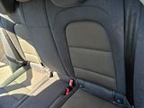 the back seats of a car are black with a red seat belt
