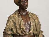 bronze statue of a man with a turban and a cane