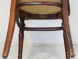 a wooden chair that is sitting in front of a white wall