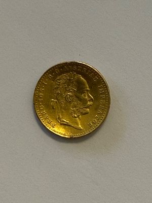 une pièce d'or posée sur une surface blanche