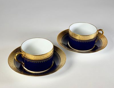 deux tasses et soucoupes à bord doré sur fond blanc