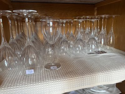 de nombreux verres à vin posés sur une étagère dans la cuisine