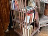 une bibliothèque sur laquelle sont posés des livres, dans un coin de la pièce