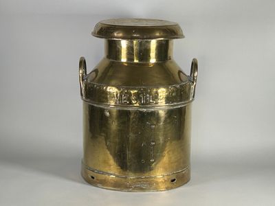 un bidon à lait ancien en laiton sur fond blanc