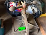 a small wooden table with a hammer on top of it next to a pile of junk