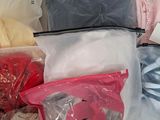 many different types of clothes in bags on a table