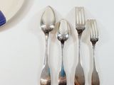 four spoons and a fork sitting on a table