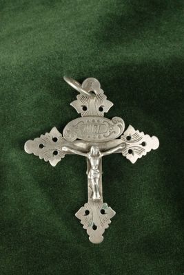 crucifix plaqué argent avec une croix sur fond de velours vert
