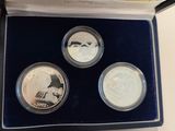 a box of three silver coins with a picture of a man on it