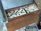 a wooden box with dominos in it on a table