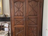 a large wooden cabinet in a room with a chair
