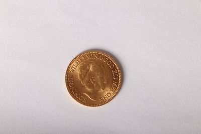 a close up of a gold coin on a white surface