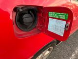 a red car with a gas pump attached to it ' s side