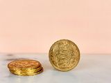two gold coins sitting on top of a marble counter top