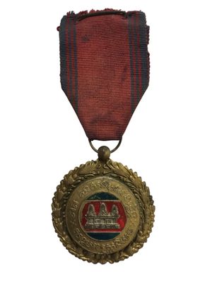 une ancienne médaille avec un ruban rouge sur fond blanc