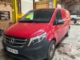 La camionnette rouge est garée dans le garage de l'immeuble.