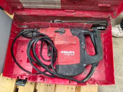 une boîte à outils rouge contenant une perceuse et un cordon d'alimentation