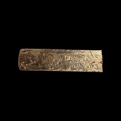 un gros plan d'un lingot d'or sur fond noir