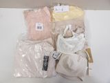 many bags of clothing and a hat sitting on a table