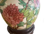 a vase with a bird on it sitting on a stand