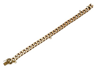gros plan d'un bracelet en chaîne en or sur fond blanc