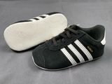 a pair of black and white shoes on a gray surface