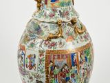 a vase with a painting on it sitting on a table