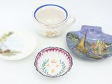 three plates, a cup, and a saucer on a table