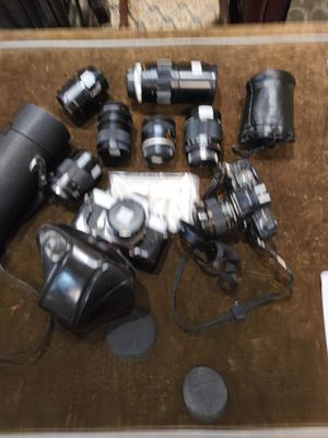 beaucoup d'appareils photo et d'autres objets posés sur la table
