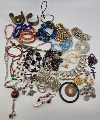 many different types of necklaces and bracelets laid out on a table