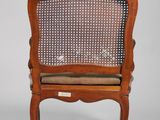 an antique wooden chair with wicker back and seat cushion