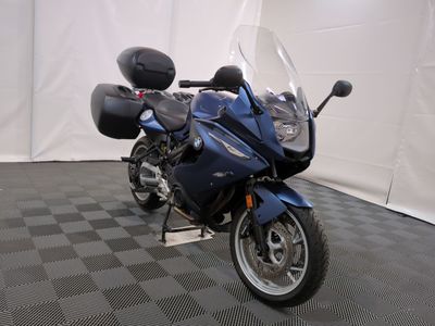 a blue motorcycle that is parked on a checkered floor