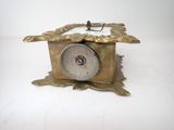 a gold clock sitting on top of a white table