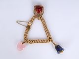 a close up of a triangle shaped brooch with a chain around it