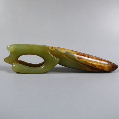 two pieces of green jade sitting on a table