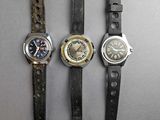 three different types of watches are displayed on a gray surface