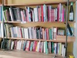 a book shelf with many books on it in a room