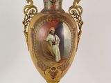 a gold vase with a picture of a woman on it